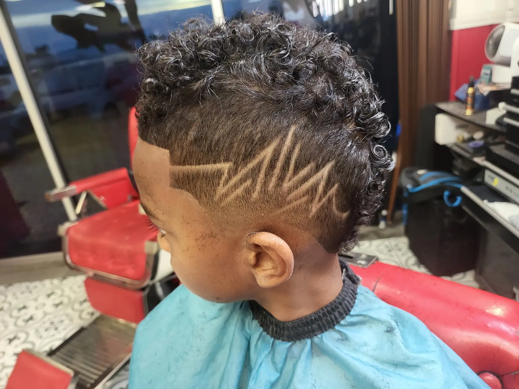 Young True Skills client with a curly mohawk and detailed freehand side design